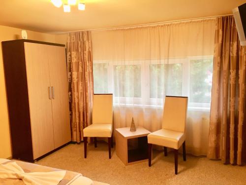 ソバタにあるPensiunea Dianaのベッドルーム1室(椅子2脚、テーブル1台、窓付)