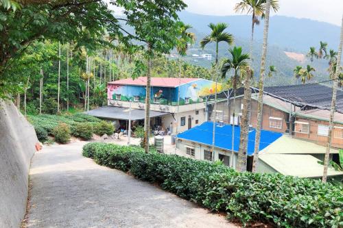 a building with a blue roof and palm trees at Look Tea House in Meishan