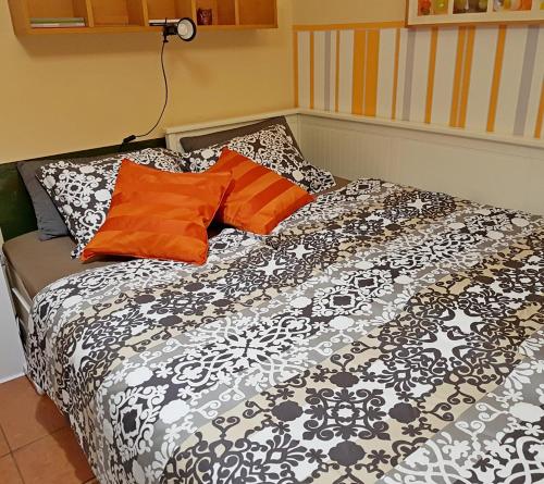 a bed with black and white sheets and orange pillows at Apartment Lisinski S in Zagreb