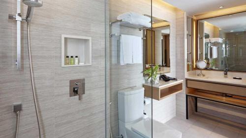 a bathroom with a shower and a toilet and a sink at Amari Phuket in Patong Beach