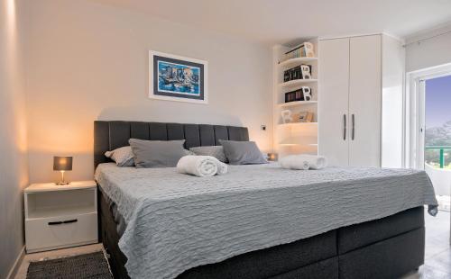 a bedroom with a large bed with two towels on it at Villa Bandic in Baška Voda