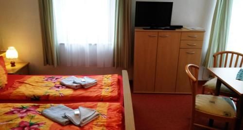 a hotel room with two beds and a tv at Erbgericht in Bad Schandau