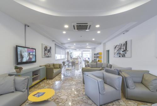 a living room with couches and a tv at Hotel Bristol in Caorle