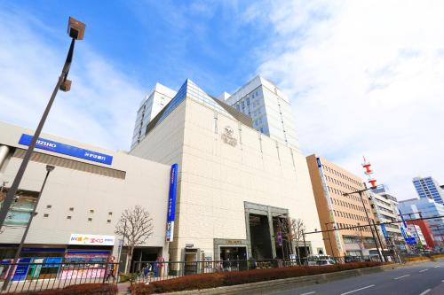a large white building on a city street at Utsunomiya Tobu Hotel Grande in Utsunomiya