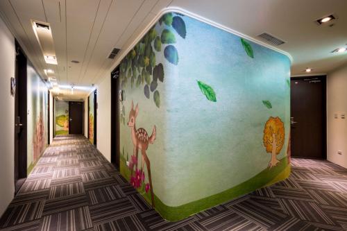 a hallway with a wall with animals painted on it at Merryday Hotel Banqiao in Taipei