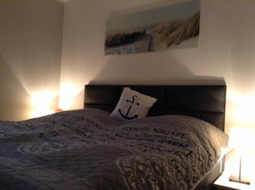 a bed with a pillow on it with two lamps at Ferienwohnung Yachthafen Wiek in Wiek auf Rügen