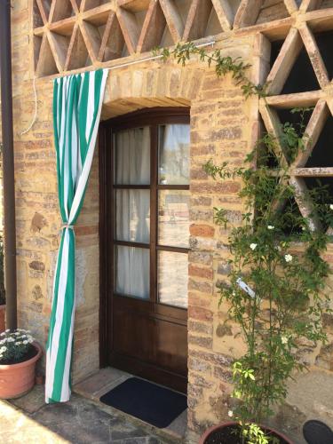 a front door of a house with a striped umbrella at Case Nell' Aia in Poggibonsi