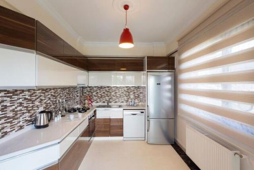 a kitchen with a stainless steel refrigerator and wooden cabinets at Nevras Resort Sapanca in Sapanca