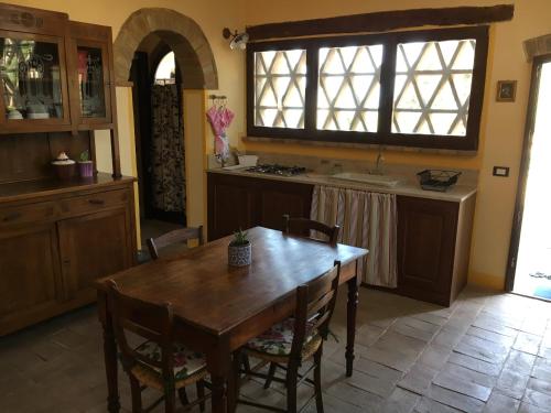 a kitchen with a wooden table and a table and chairs at Case Nell' Aia in Poggibonsi
