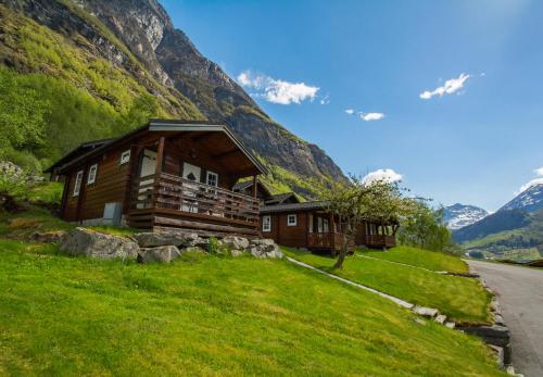 a large stone building with a view of the mountains at Grande Hytteutleige og Camping in Geiranger