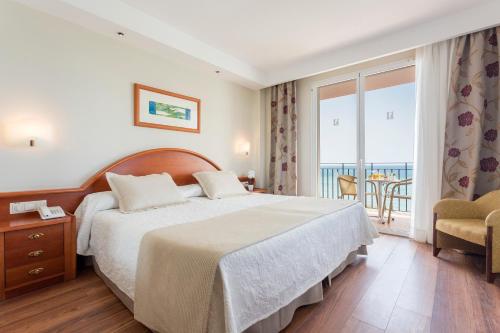 um quarto de hotel com uma cama e uma varanda em Hipotels Flamenco Conil em Conil de la Frontera