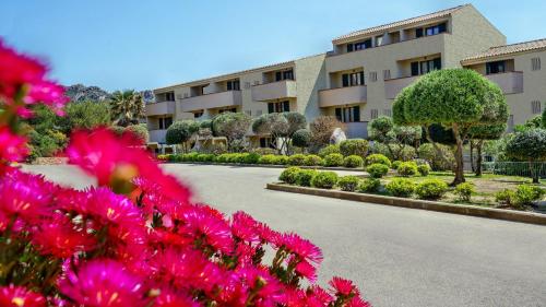 a building with pink flowers in front of a road at Blu Baita in La Maddalena