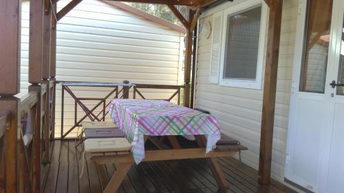 eine Veranda mit einem Tisch und einem Regenschirm darauf in der Unterkunft Mobile Home Cinzia in Pula