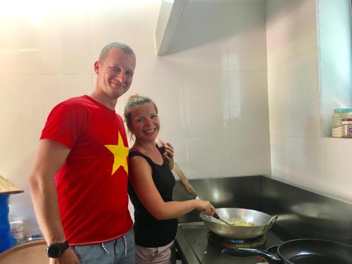 a man and woman standing in a kitchen preparing food at Tam Coc Friendly Homestay in Ninh Binh