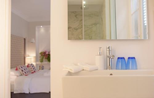 a bathroom with a sink and a mirror at Merchant Liston Suite in Corfu