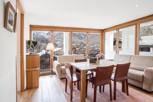 ツェルマットにあるSonnmatten Boutique Hotel & Apartments Zermattのリビングルーム(テーブル、椅子、ソファ付)