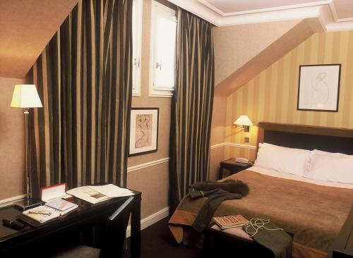 a hotel room with a bed and a window at Victoires Opera in Paris