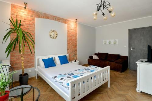 a bedroom with a white bed and a brick wall at Hostel w ogrodzie in Grudziądz