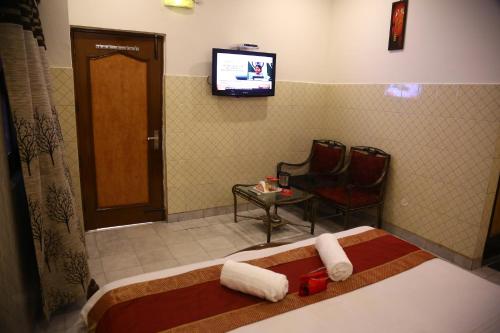 a room with a bed and a tv and a chair at Hotel City Plaza 7 in Chandīgarh