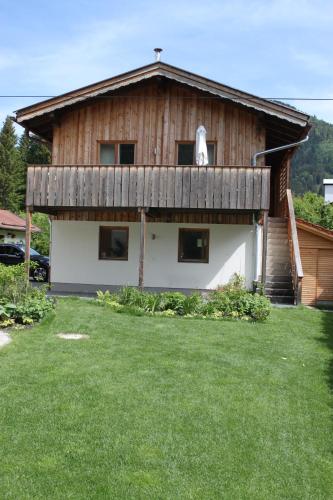 a large wooden house with a grass yard in front of it at Ferienwohnung Springer in Schliersee