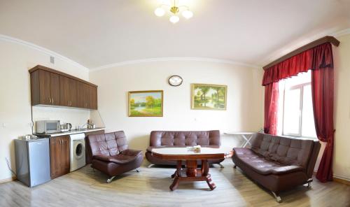 a living room with two chairs and a table and a kitchen at Family Hotel in Yerevan