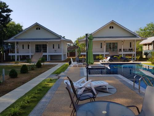 a villa with a swimming pool and a house at Poolside Bungalows in Khao Lak