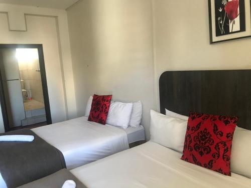 a hotel room with two beds and a mirror at Businessburg Hotel in Johannesburg