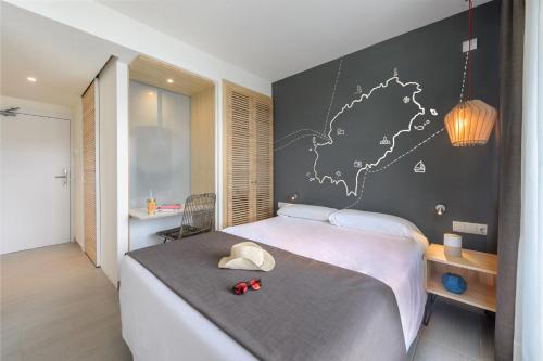 a bedroom with a bed with a map on the wall at Hotel Vibra Cala Tarida-3SUP in Cala Tarida
