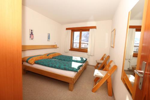 Schlafzimmer mit einem Bett und einem Fenster in der Unterkunft Chesa Blais 7 in Pontresina