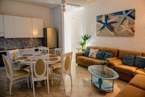Una sala de estar con un sofá y una mesa y una cocina. en Villa Saline, en Palinuro