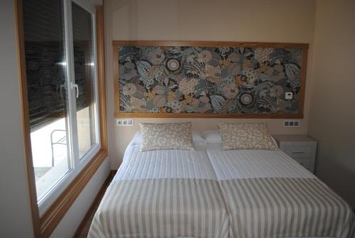a small bedroom with a bed and a window at Casa Chelo Alojamientos Turisticos in Mazaricos