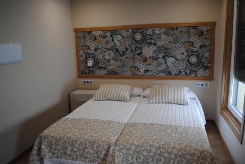 a bedroom with a bed with two pillows at Casa Chelo Alojamientos Turisticos in Mazaricos