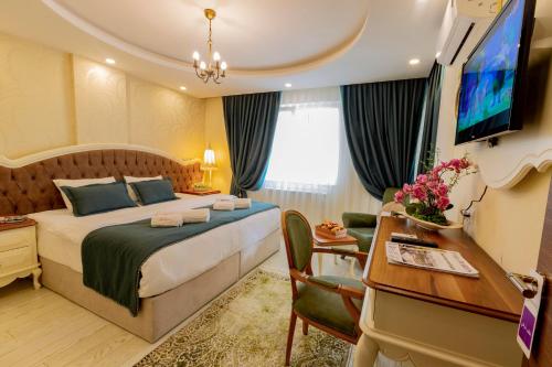 a bedroom with a bed and a desk and a television at Andalouse Suite Hotel in Trabzon
