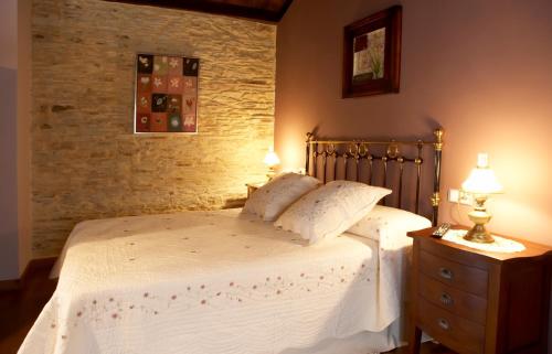 a bedroom with a bed with two pillows on it at Hotel Rural Casona Trabadelo in Vegadeo
