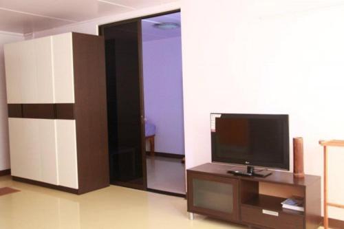 a living room with a flat screen tv on a table at IMPACT Don Mueang Bangkok Guest House in Nonthaburi