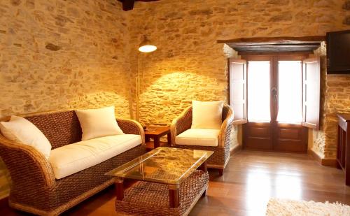 a living room with two couches and a coffee table at Hotel Rural Casona Trabadelo in Vegadeo