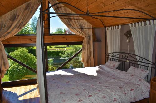 um quarto com uma cama e uma grande janela em Gites-Clairiere-Ardenne em Louftémont