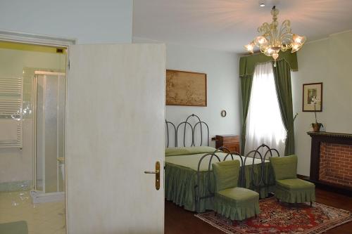 a bedroom with a bed and two chairs and a chandelier at Agriturismo Tenuta Goro Veneto in Ariano nel Polesine