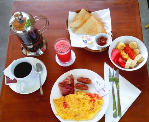 un tavolo con piatti per la colazione e una tazza di caffè di Villa Hoomea Private Pool a Gili Air