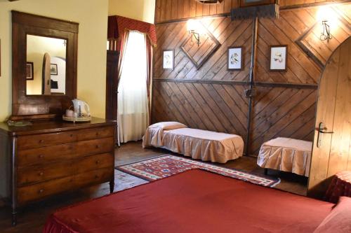 a bedroom with two beds and a dresser and a mirror at Agriturismo Tenuta Goro Veneto in Ariano nel Polesine