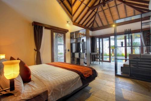 a bedroom with a bed and a living room at Villa Esperanto Seminyak in Seminyak