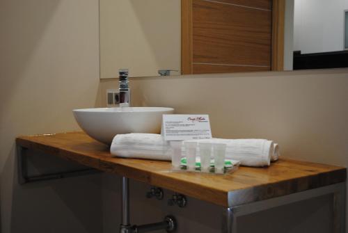 a bathroom counter with a sink and towels on it at Casa Chelo Alojamientos Turisticos in Mazaricos