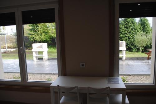 a table and chairs in front of a window at Casa Chelo Alojamientos Turisticos in Mazaricos