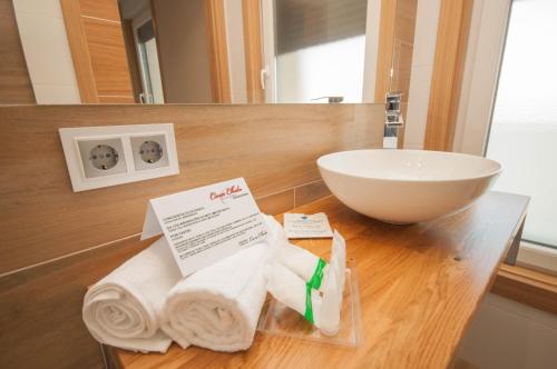 a bathroom with a sink and towels on a counter at Casa Chelo Alojamientos Turisticos in Mazaricos