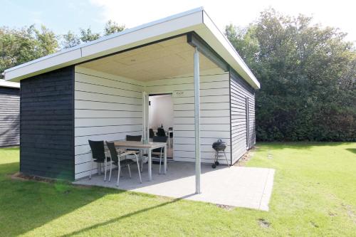 a small shed with a table and chairs in a yard at Esbjerg Camping in Esbjerg