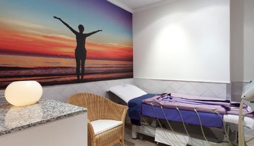 a bedroom with a painting of a woman with her arms up at Senator Marbella in Marbella