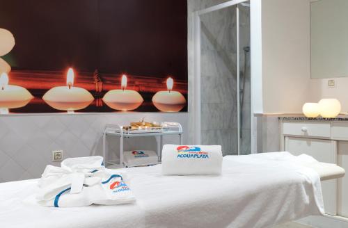 a room with a white bed with a bag and candles at Senator Marbella in Marbella