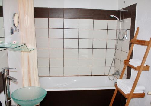 La salle de bains est pourvue d'une baignoire, d'un lavabo et de toilettes. dans l'établissement Hôtel - Restaurant La Chaloupe, à Le Port-des-Barques