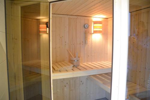 a sauna with wooden walls and a glass door at Pension Adlerhorst in Ramsau am Dachstein