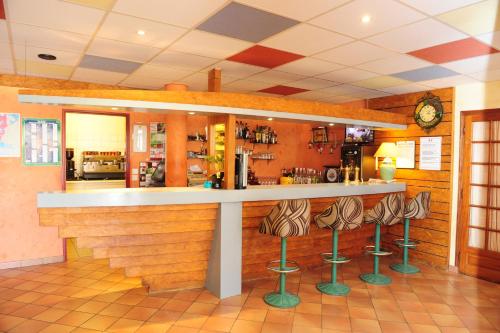 a bar in a restaurant with stools at Logis Argonne Hôtel in Vouziers